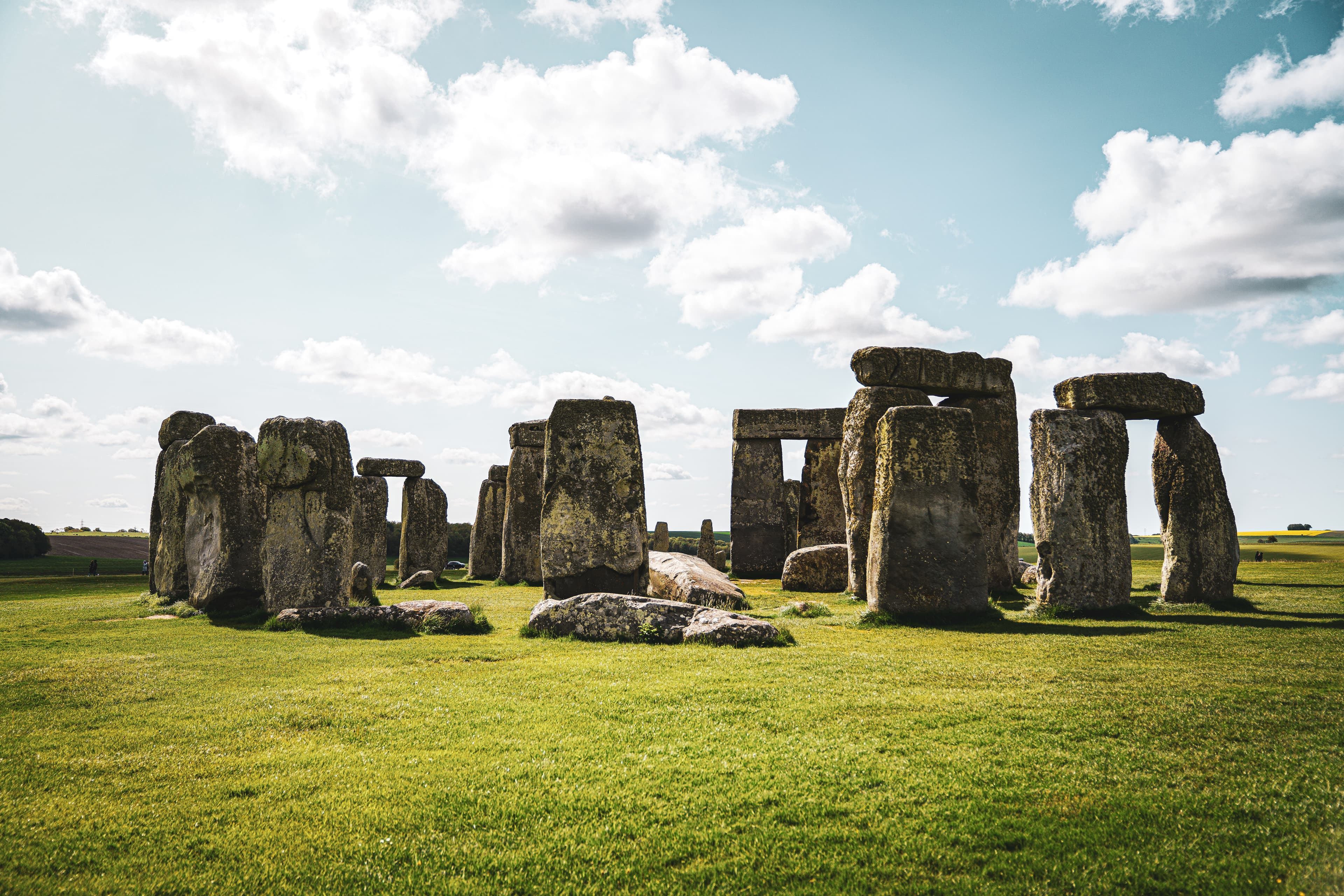Stonehenge standing beneath a bright sky in the English countryside.