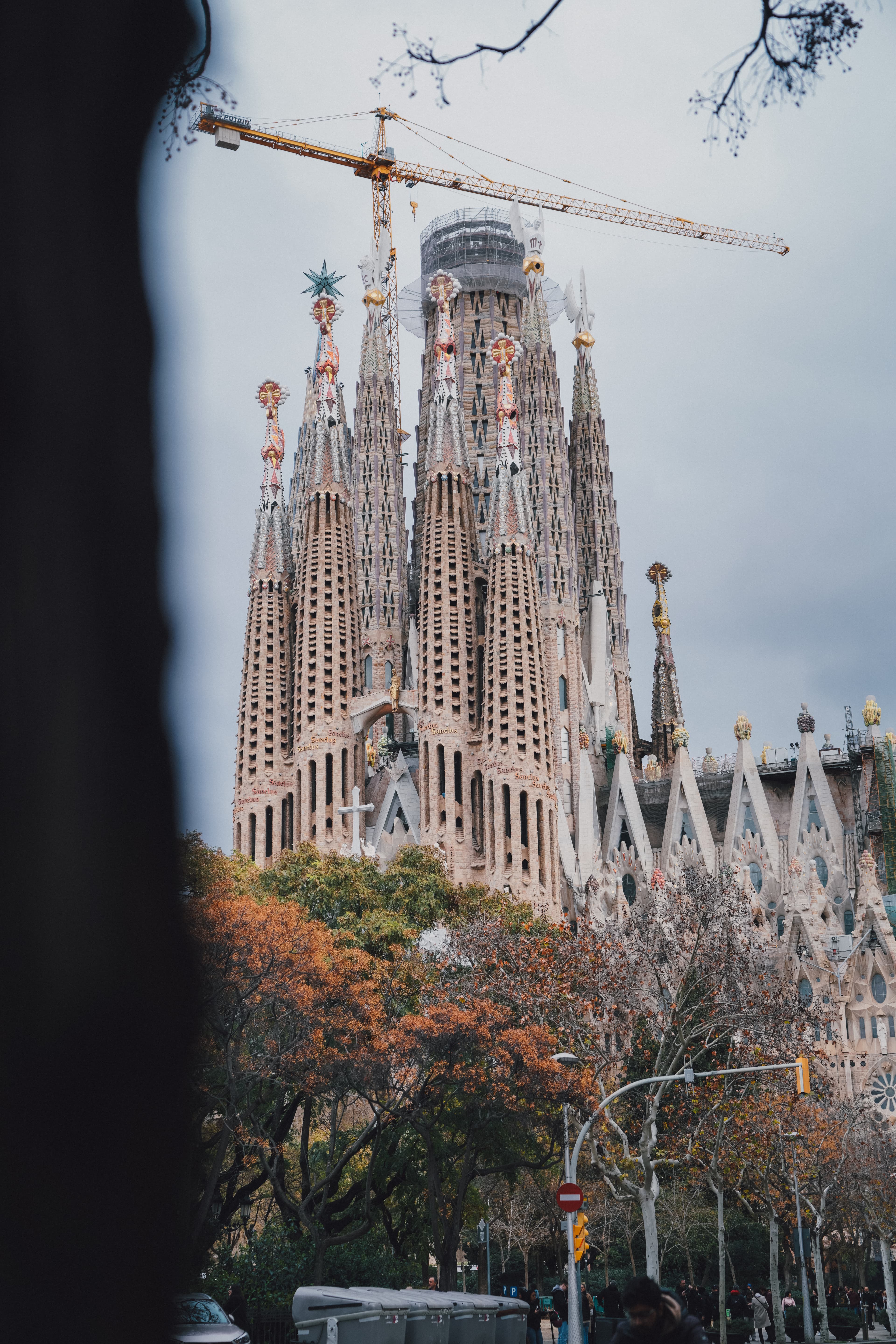 La Sagrada Família cathedral in Barcelona surrounded by cranes during construction.
